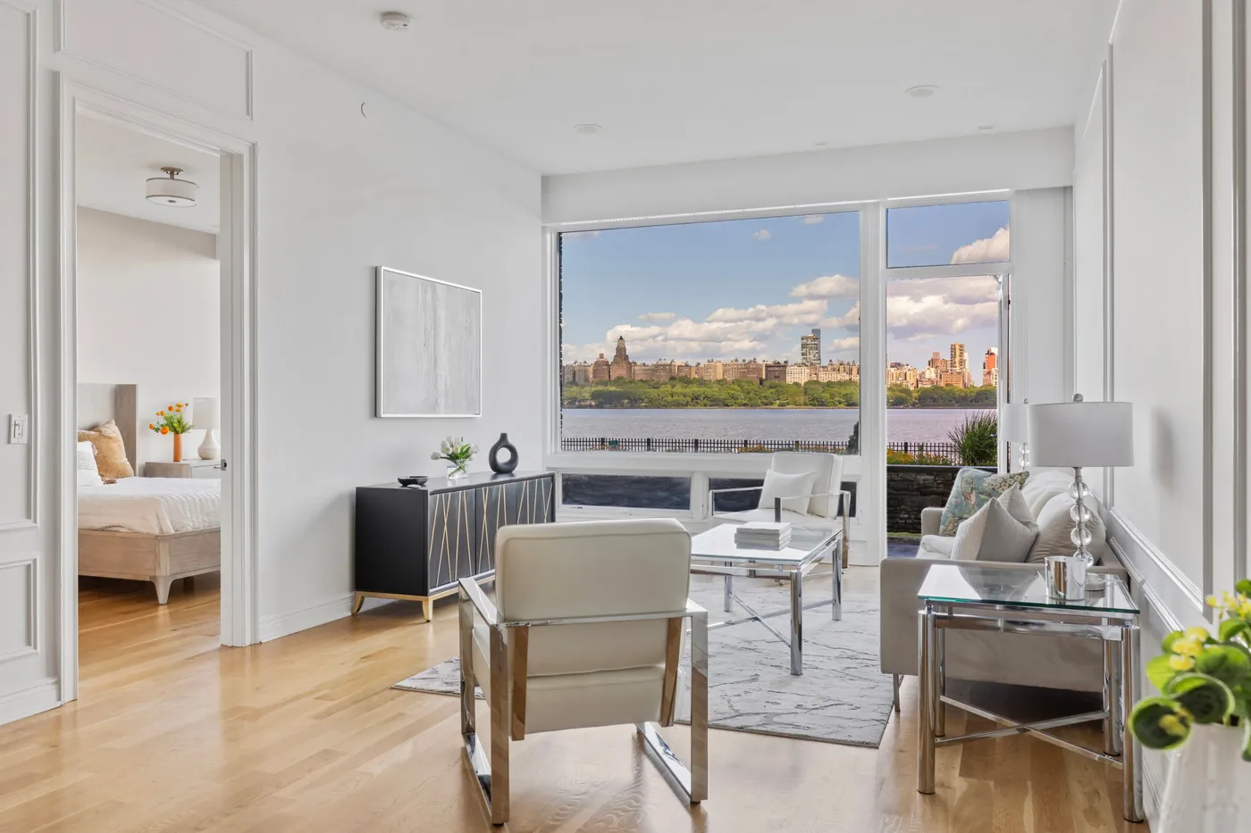 Bright living room with a large window framing the Hudson River and the Manhattan skyline